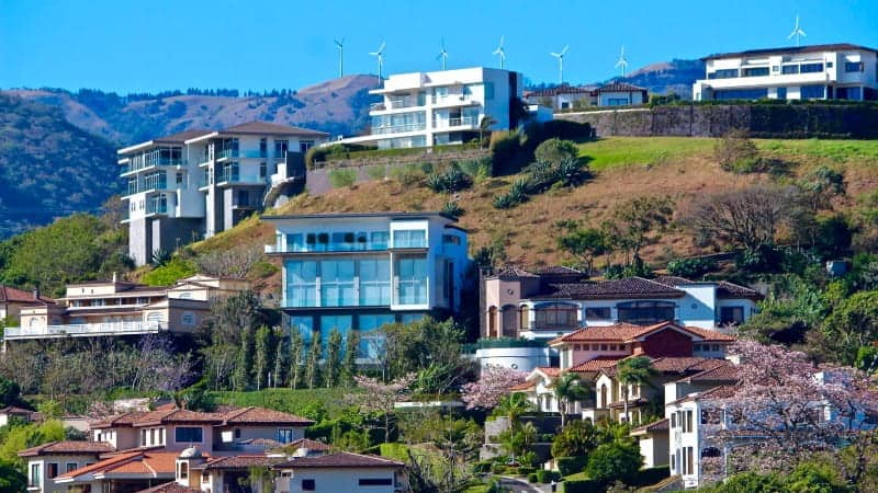 A city with modern buildings and more historic building styles set on a hill in a city in Costa Rica.