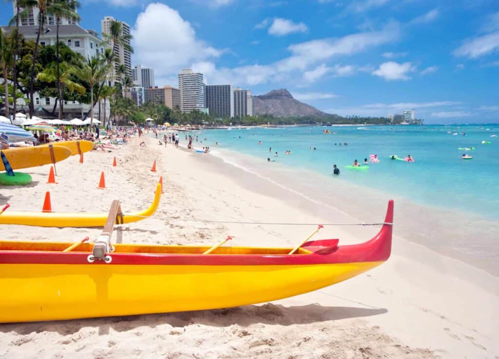 Several boats and people playing in the turquoise waters at Waikiki Beach on Oahu.