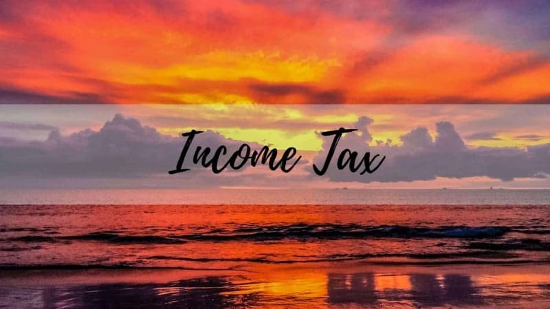 An overlay that reads "income tax" over a beach at sunset in Costa Rica.
