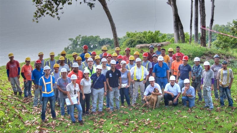 A group of men and women standing in hard hats in the jungle in Costa Rica.