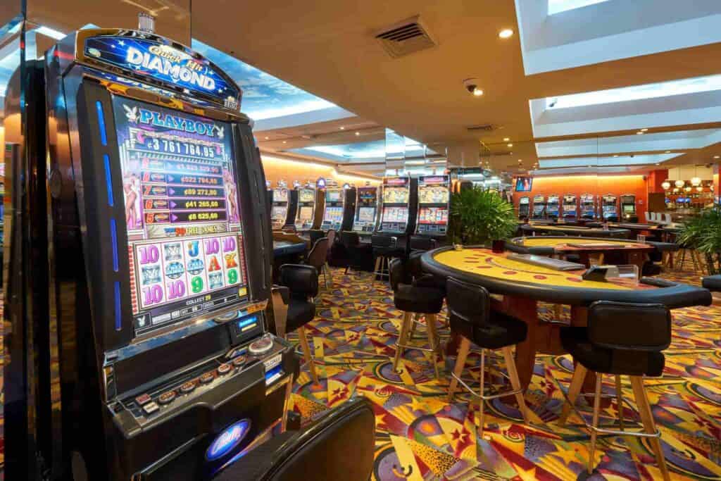 A casino, with table games, a slot machine, and colorful carpet flooring, in Costa Rica.