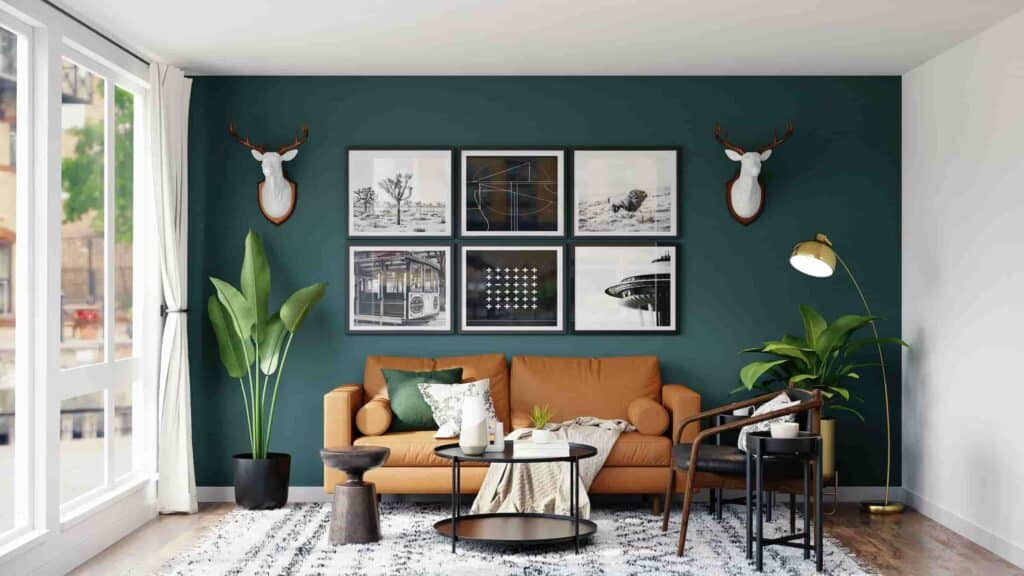 A minimalist living room with a blue wall, two white deer heads, picture frames, and plants and greenery.