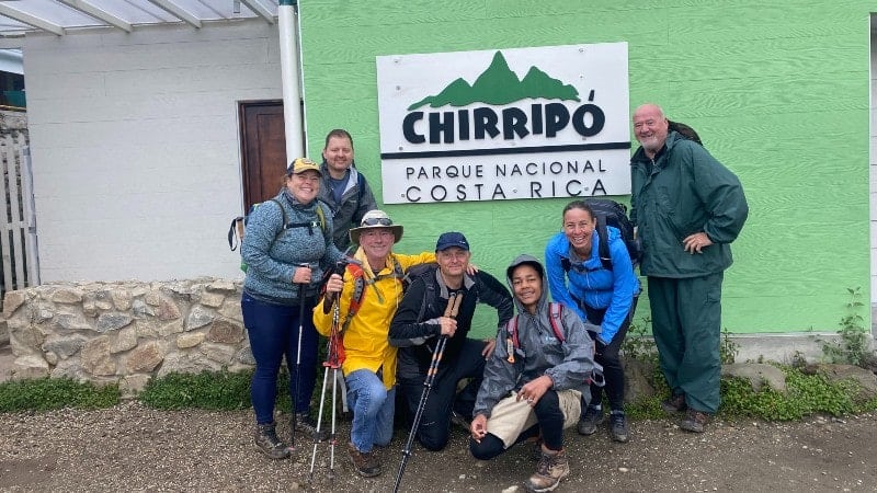 A group of people standing outside the sign for Chirripo National Park in Costa Rica.