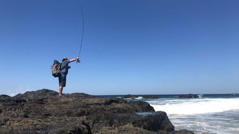 A man casting a line from the beach in Costa Rica.