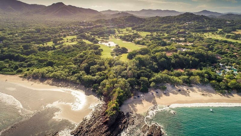 Two magnificent crescent sandy beaches in Costa Rica are intersected by a rocky point, with a champion golf course just back from the tree-lined shore. On the left, the lovely Playa Brasilito, on the right, the world class Playa Conchal.