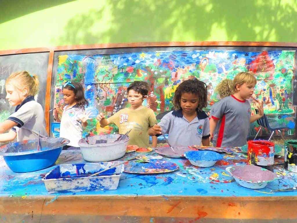 Kids enjoying a messy and FUN time painting at Educarte School