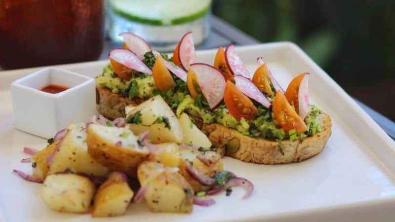 avocado toast made with homemade bread and a side of potatoes