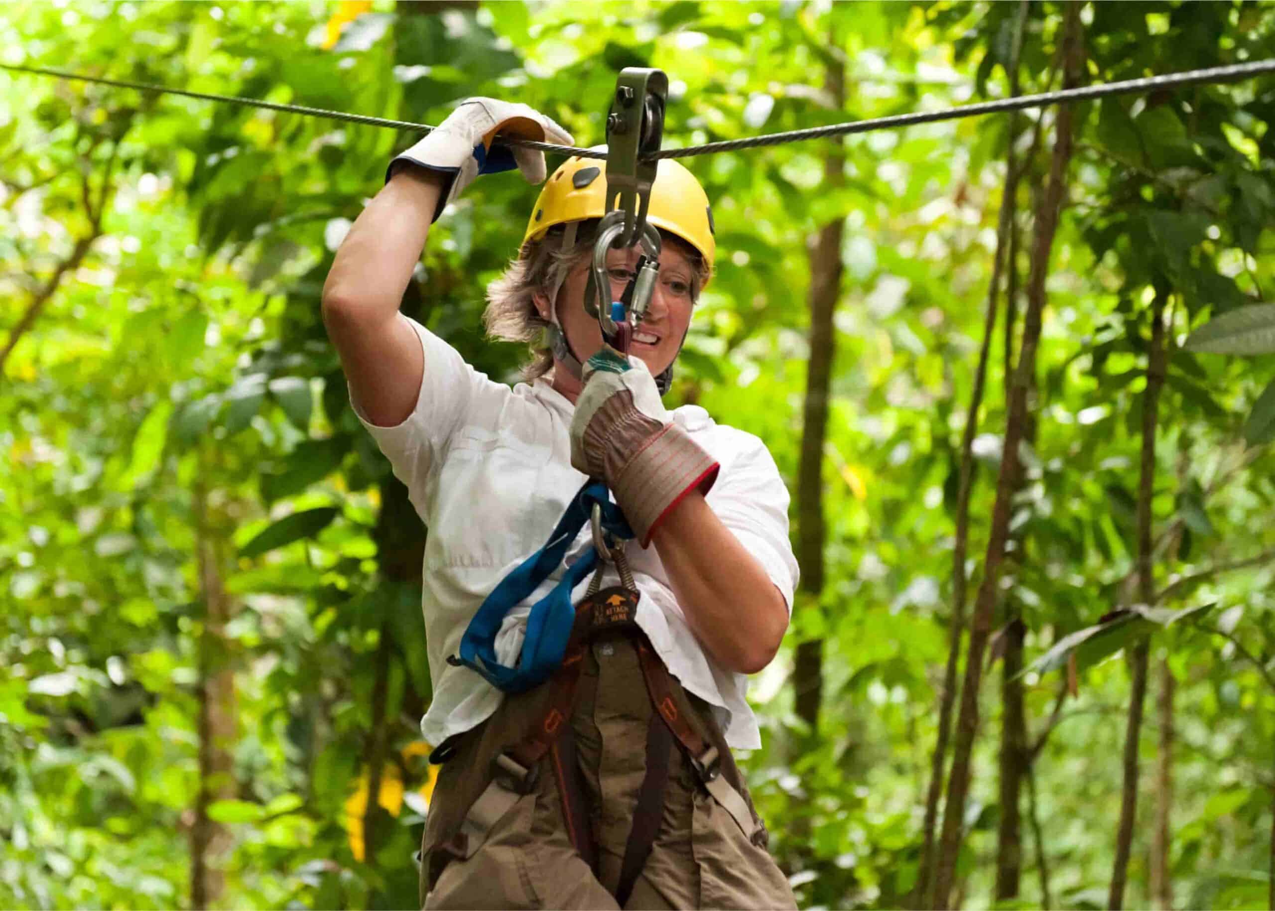 a woman on a zipline going through a forest in Costa Rica