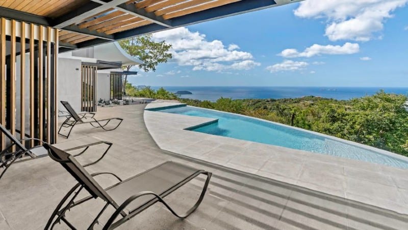 A serene pool and patio area with a breathtaking ocean view at a vacation rental in Costa Rica.
