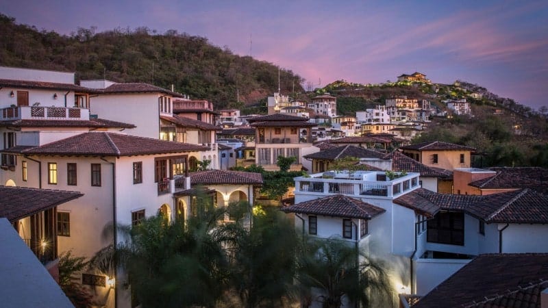 A Costa Rican town at dusk with mountains in the background.
